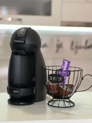 a coffee maker sitting on a counter next to a cup at Mirkovic Lux apartman in Niš