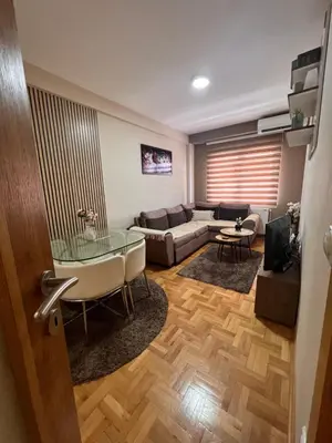 a living room with a couch and a glass table at Mirkovic Lux apartman in Niš