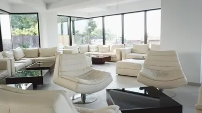 a living room with white furniture and large windows at Plaža in Varvarin