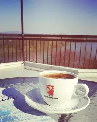 a cup of coffee sitting on a plate on a table at Plaža in Varvarin