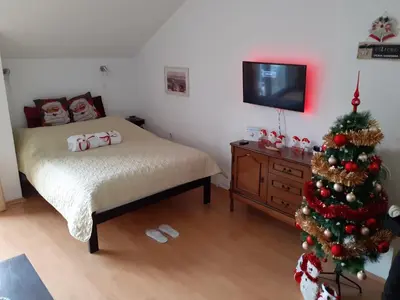 a bedroom with a christmas tree and a bed at Sky Apartman in Soko Banja