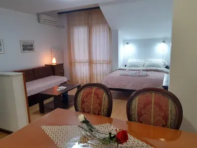 a living room with a bed and a table and chairs at Sky Apartman in Soko Banja