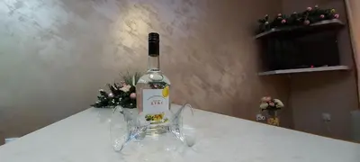 a bottle of wine sitting on a table with flowers at Apartmani Neca in Vrnjačka Banja