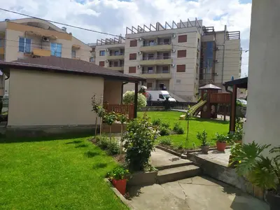 a yard with a building in the background at Apartmani Neca in Vrnjačka Banja