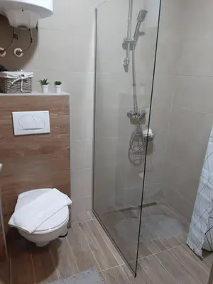 a bathroom with a glass shower with a toilet at Kop Milmari P32 in Kopaonik