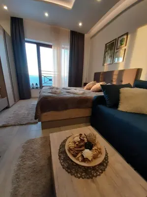 a living room with a bed and a blue couch at Kop Milmari P32 in Kopaonik