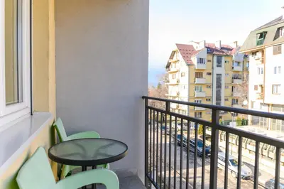 a balcony with two chairs and a table and a window at Apartman Saga Premium Garaza Parking Vauceri Ne in Soko Banja