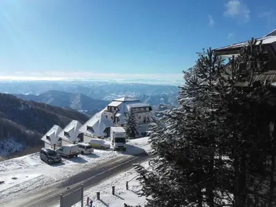 a ski lodge with snow on the ground on a mountain at Dvori E11 Hilltop in Kopaonik