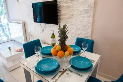 a dining room table with a pineapple and blue plates at Turist Apartment in Niš