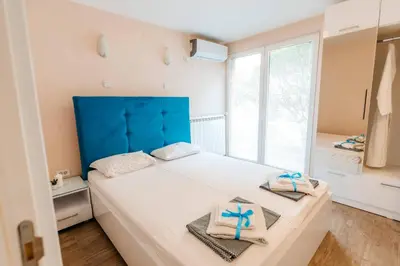 a bedroom with a large bed with towels on it at Turist Apartment in Niš