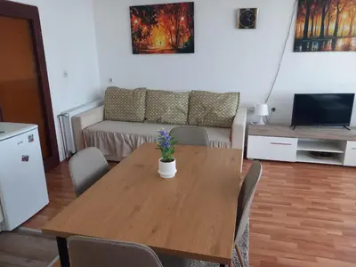 a living room with a wooden table and a couch at Apartmani Ćosić in Kuršumlija