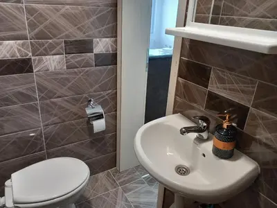 a bathroom with a sink and a toilet at Apartmani Ćosić in Kuršumlija