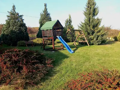a playground in a yard with a slide at Apartmani Ćosić in Kuršumlija