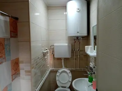 a small bathroom with a toilet and a sink at Apartmani Ćosić in Kuršumlija