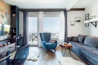 a living room with a couch and a blue chair at Srebrna Petica in Kopaonik