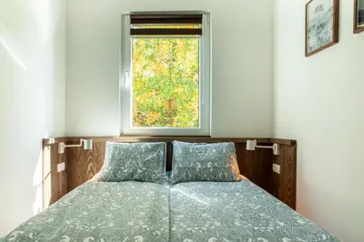 a bed in a room with a window at Srebrna Petica in Kopaonik