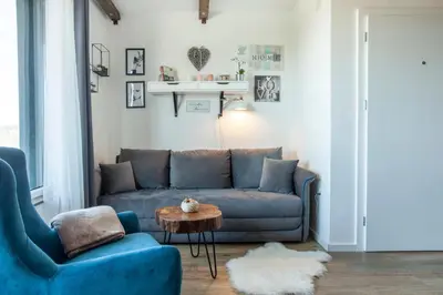 a living room with a blue couch and a table at Srebrna Petica in Kopaonik
