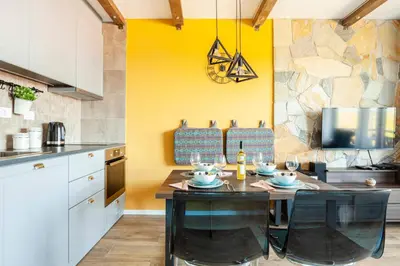 a kitchen with a table with chairs and a yellow wall at Srebrna Petica in Kopaonik