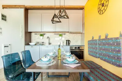 a kitchen with a wooden table and blue chairs at Srebrna Petica in Kopaonik