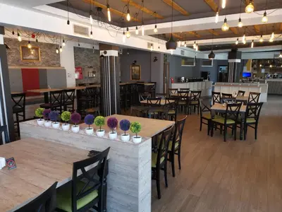 a restaurant with wooden tables and chairs and a bar at L18 apartment Milmari in Kopaonik