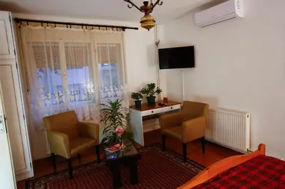 a living room with two chairs and a table and a television at Apartman Carpe Diem in Zaječar