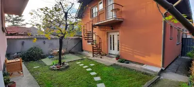 a small yard with a tree in front of a building at Apartman Carpe Diem in Zaječar
