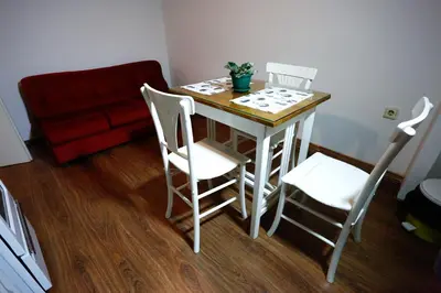 a small table with four chairs and a red couch at Apartman Carpe Diem in Zaječar