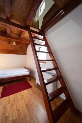a room with a staircase and a red rug at Planinske Vile M&S in Kopaonik