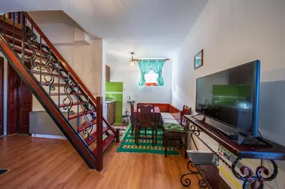 a living room with a staircase with a flat screen tv at Planinske Vile M&S in Kopaonik