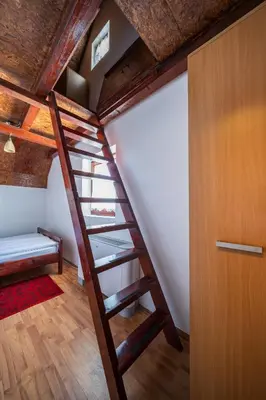 a wooden staircase in a room with a bed at Planinske Vile M&S in Kopaonik