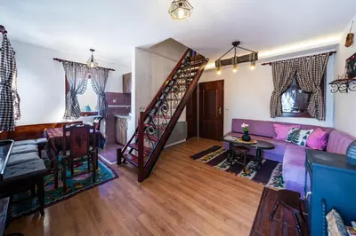 a living room with a couch and a staircase at Planinske Vile M&S in Kopaonik