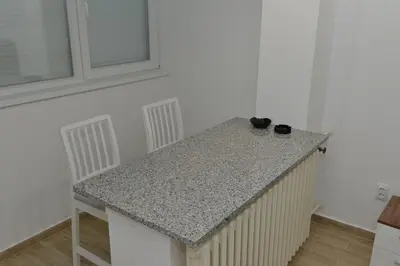 a kitchen counter with two chairs and a table at Apartman Jankulovski in Kraljevo