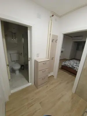 a bedroom with a bed and a bathroom with a mirror at Apartman Jankulovski in Kraljevo