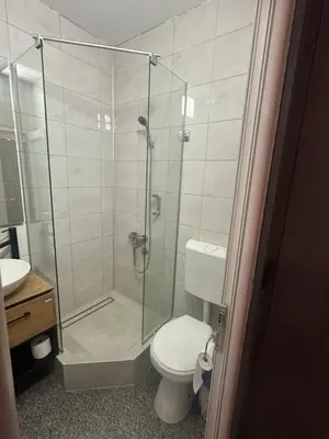 a bathroom with a toilet and a glass shower at Prenoćište Binta in Vranje