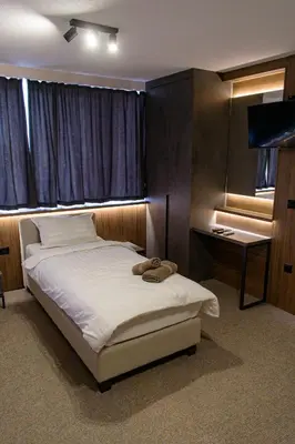 a bedroom with a bed and a desk and a television at Prenoćište Binta in Vranje