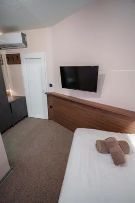 a hotel room with a bed and a flat screen tv at Prenoćište Binta in Vranje