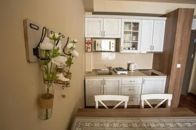 a kitchen with white cabinets and a vase of flowers at Planinska bajka - Kraljevi čardaci in Kopaonik