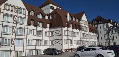 a large building with cars parked in front of it at Planinska bajka - Kraljevi čardaci in Kopaonik