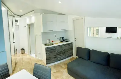 a living room with a couch and a kitchen at Vila Plan - Centar Kopaonik in Kopaonik