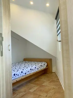 a small bedroom with a bed in a attic at Vila Plan - Centar Kopaonik in Kopaonik