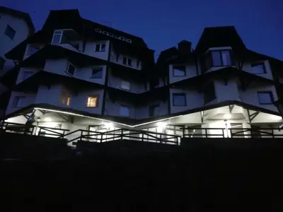 a large white building with lights in the dark at Vila Plan - Centar Kopaonik in Kopaonik