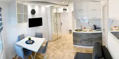 a kitchen and a living room with a table and chairs at Vila Plan - Centar Kopaonik in Kopaonik
