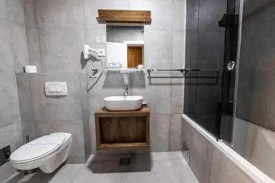 a bathroom with a sink and a toilet and a shower at Hammeum Hotel in Prokuplje