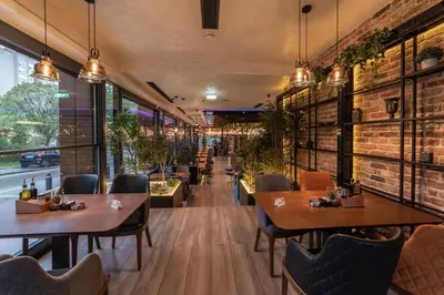 a restaurant with tables and chairs and a brick wall at Hammeum Hotel in Prokuplje
