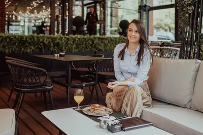 a woman sitting on a couch in a restaurant at Hammeum Hotel in Prokuplje