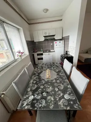 a kitchen with a table and chairs and a kitchen with a table and a table at apartman centar S in Pirot