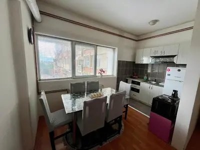 a kitchen with a table and chairs in a kitchen at apartman centar S in Pirot