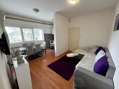 a living room with a couch and a dining room at apartman centar S in Pirot