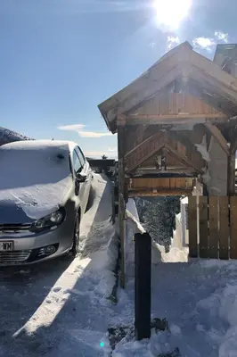 a car parked next to a building in the snow at Kostovac Boutique Homes - Sauna in Kopaonik
