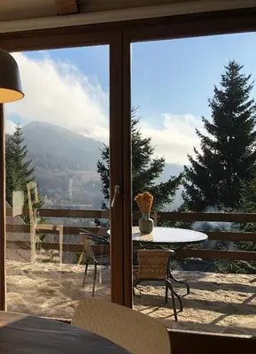 a patio with a table and a view of a mountain at Kostovac Boutique Homes - Sauna in Kopaonik